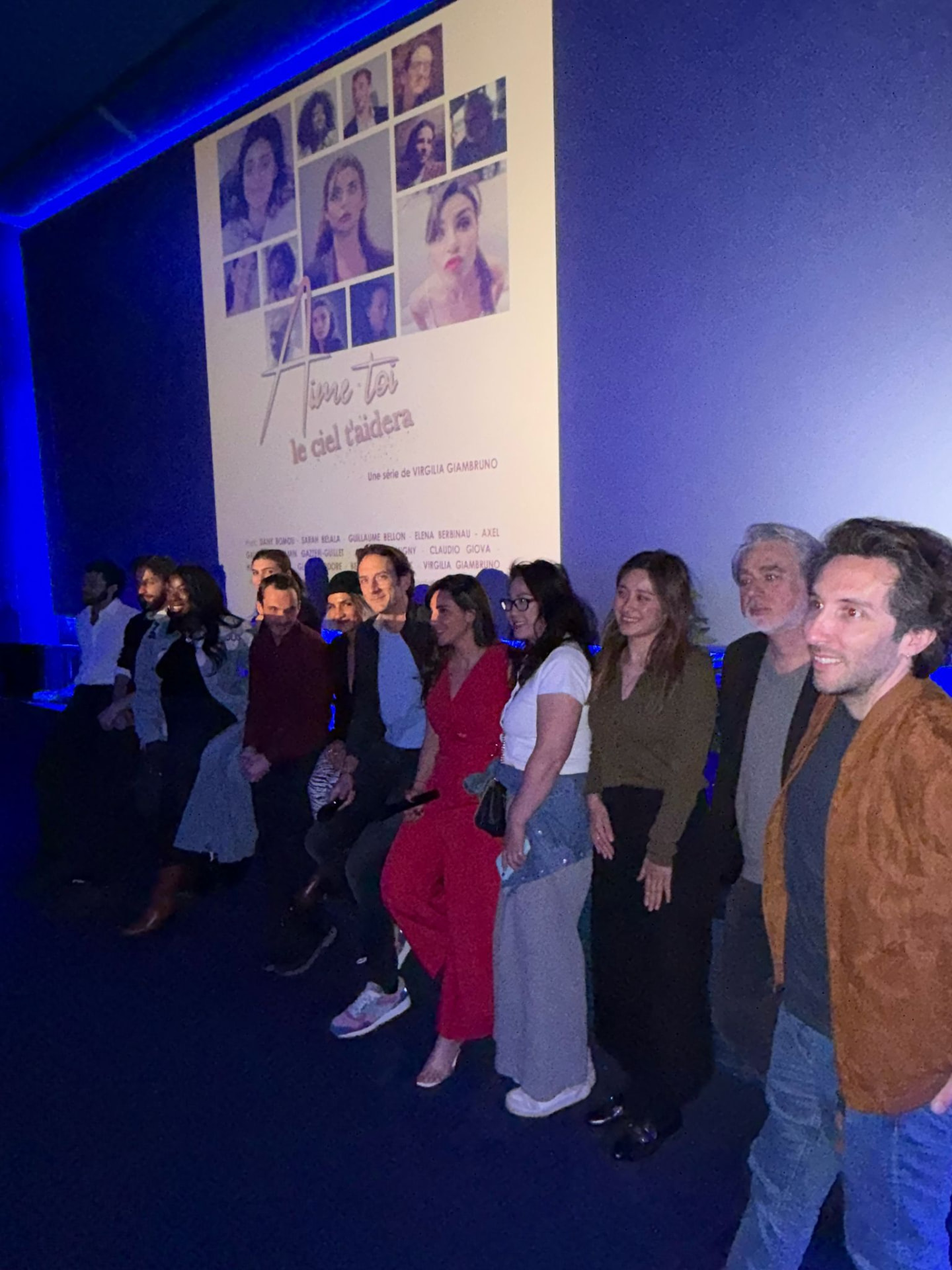 Projection en salle — l'équipe devant l'affiche « Aime-toi, le ciel t'aidera »